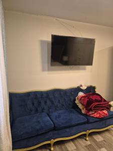 a blue couch in a living room with a flat screen tv at La casa de la Playa in Primo Tapia
