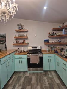 a kitchen with blue cabinets and a stove at La casa de la Playa in Primo Tapia