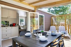 a kitchen and dining room with a wooden table and chairs at Mobilehome Vallon 53 in Saint-Gervais