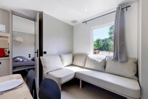 a living room with a couch and a window at Mobilehome Vallon 53 in Saint-Gervais +17 photos