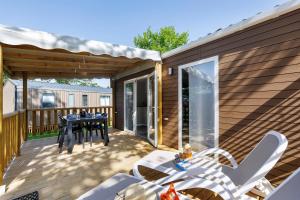a screened in deck with a table and chairs at Mobilehome Vallon 53 in Saint-Gervais