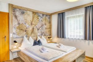 a bedroom with a large bed with towels on it at Appartements Spitaler in Ried im Zillertal