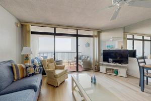 a living room with a blue couch and a tv at Pyramid 6K in Ocean City