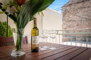 a bottle of wine and three wine glasses on a table at Guesthouse Wish in Stari Grad