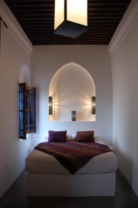 a bedroom with a bed with a large mirror on the wall at Riad Dar Soufa in Rabat