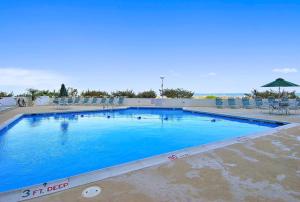a large blue swimming pool with chairs and an umbrella at Pyramid 10C in Ocean City