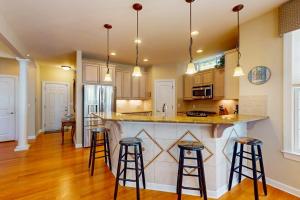 a kitchen with a large island with bar stools at The Point 1437 in Ocean Pines