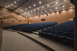 an empty auditorium with blue chairs and lights at Tauá Hotel e Convention João pessoa in João Pessoa +129 photos