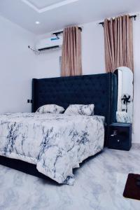 a bedroom with a bed with a blue and white comforter at Welcome to Originclicks Apartments! in Ebute Ikorodu