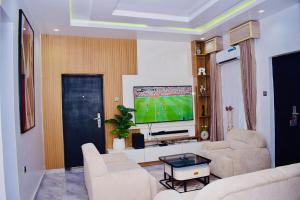 a living room with a couch and a tv at Welcome to Originclicks Apartments! in Ebute Ikorodu