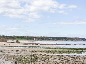 a beach with people on the sand and the water at Needle Cottage in Cullen