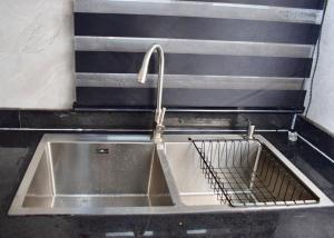 a kitchen sink with a faucet and a strainer at Welcome to Originclicks Apartments! in Ebute Ikorodu +9 photos