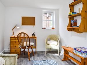 a room with a desk and a chair and a table at Needle Cottage in Cullen +12 photos