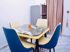 a dining room with a table and blue chairs at Welcome to Originclicks Apartments! in Ebute Ikorodu