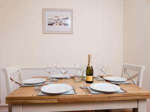 a wooden table with glasses and a bottle of wine at Peacehaven in Shalfleet