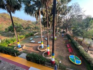 an empty park with palm trees and a playground at Mountain Bliss Villa Gorai in Mumbai