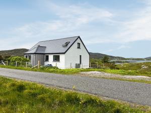 a white house on the side of a road at Grianan in Eriskay