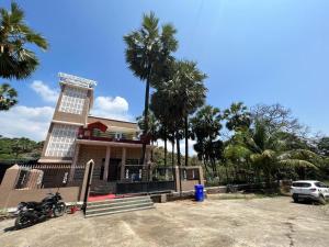 a motorcycle parked in front of a building with palm trees at Mountain Bliss Villa Gorai in Mumbai