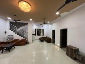 a large living room with couches and a staircase at Mountain Bliss Villa Gorai in Mumbai