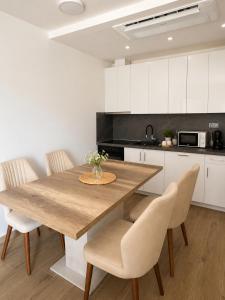a kitchen with a wooden table and chairs at Our story Apartment in Milovići
