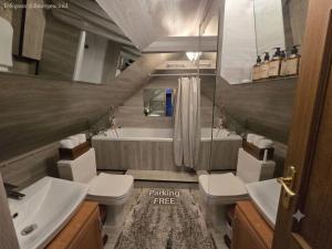 a bathroom with two toilets and a sink and a tub at Ismail&Stefan in Chişinău