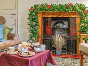 a living room with a table with food and a fireplace at Number 4 in Llandeilo