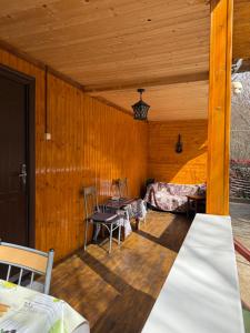 a room with wooden walls and a table and chairs at Cabana lucia in Tarcău-Gheuca