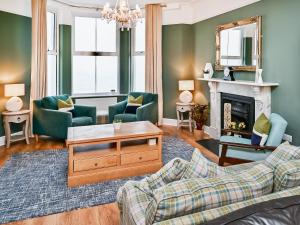 a living room with a couch and a fireplace at Glan Y Mor - Uk52092 in Criccieth