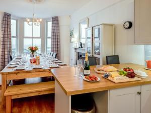 a dining room with a table with food and wine glasses at Glan Y Mor - Uk52092 in Criccieth