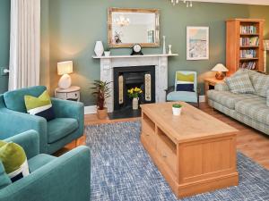 a living room with a couch and a fireplace at Glan Y Mor - Uk52092 in Criccieth