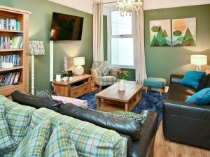 a living room with a couch and a table at Glan Y Mor - Uk52092 in Criccieth +25 photos