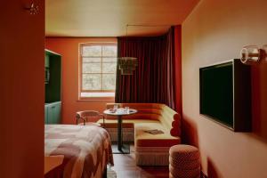 a room with a bed and a table and a chair at Ember Locke Kensington in London
