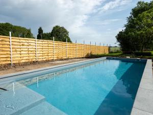 a swimming pool in front of a wooden fence at Anc. Seigneurie de Boucaut in Leuze-en-Hainaut