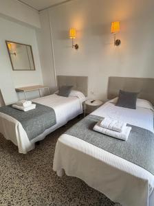 two beds sitting next to each other in a room at Hostal Paco Marbella in Marbella