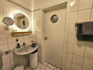 a small bathroom with a sink and a mirror at Eifelglück in Heimbach +37 photos