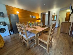 a dining room with a table and chairs and a refrigerator at Artemis 402 2 chambres et coin montagne in Brides-les-Bains +3 photos