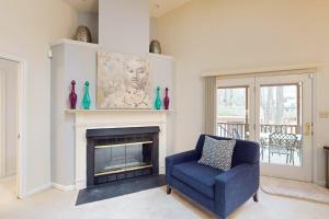 a living room with a blue chair and a fireplace at 22 Harpoon rd in Ocean Pines