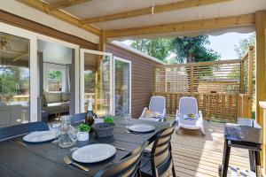 a patio with a table and chairs on a deck at Mobilehome Vallon 49 in Saint-Gervais