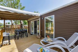 a patio with a table and chairs on a deck at Mobilehome Vallon 49 in Saint-Gervais