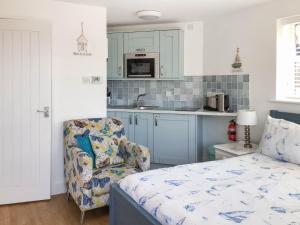 a kitchen with a bed and a chair in a room at Farthings - 19292 in Bridport