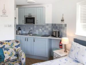 a kitchen with a sink and a microwave at Farthings - 19292 in Bridport