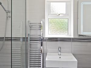 a bathroom with a sink and a shower at Farthings - 19292 in Bridport +4 photos
