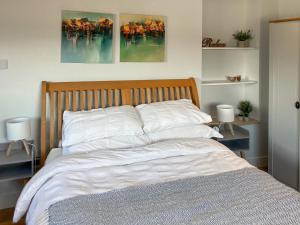 a bedroom with a bed with white sheets and two lamps at Lower Mount Orchard in Stroud +10 photos