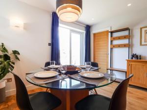 a dining room with a glass table and chairs at Lower Mount Orchard in Stroud