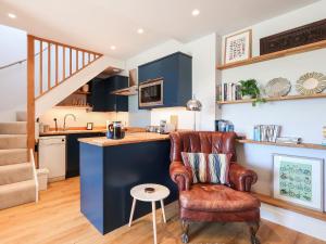 a kitchen with blue cabinets and a leather chair at Lower Mount Orchard in Stroud