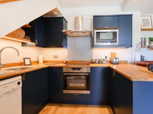 a kitchen with blue cabinets and a sink at Lower Mount Orchard in Stroud