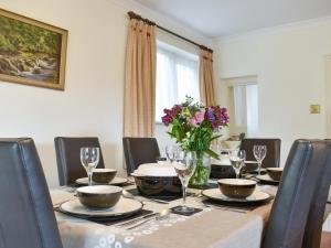 a dining room with a table with a vase of flowers at Oak Tree Cottage - E5062 in Birley