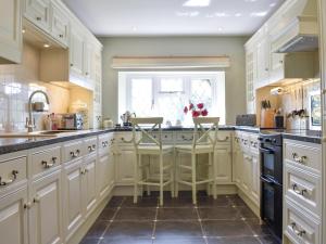 a kitchen with white cabinets and a window at Oak Tree Cottage - E5062 in Birley
