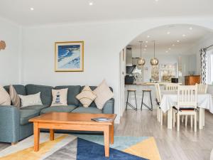 a living room with a blue couch and a table at The Dawn in Looe