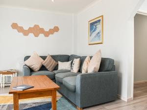 a living room with a couch and a table at The Dawn in Looe